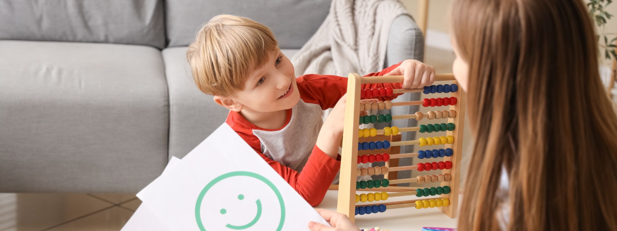 Little Boy with level 2 autism Playing with Abacus at Psychologist's Office.